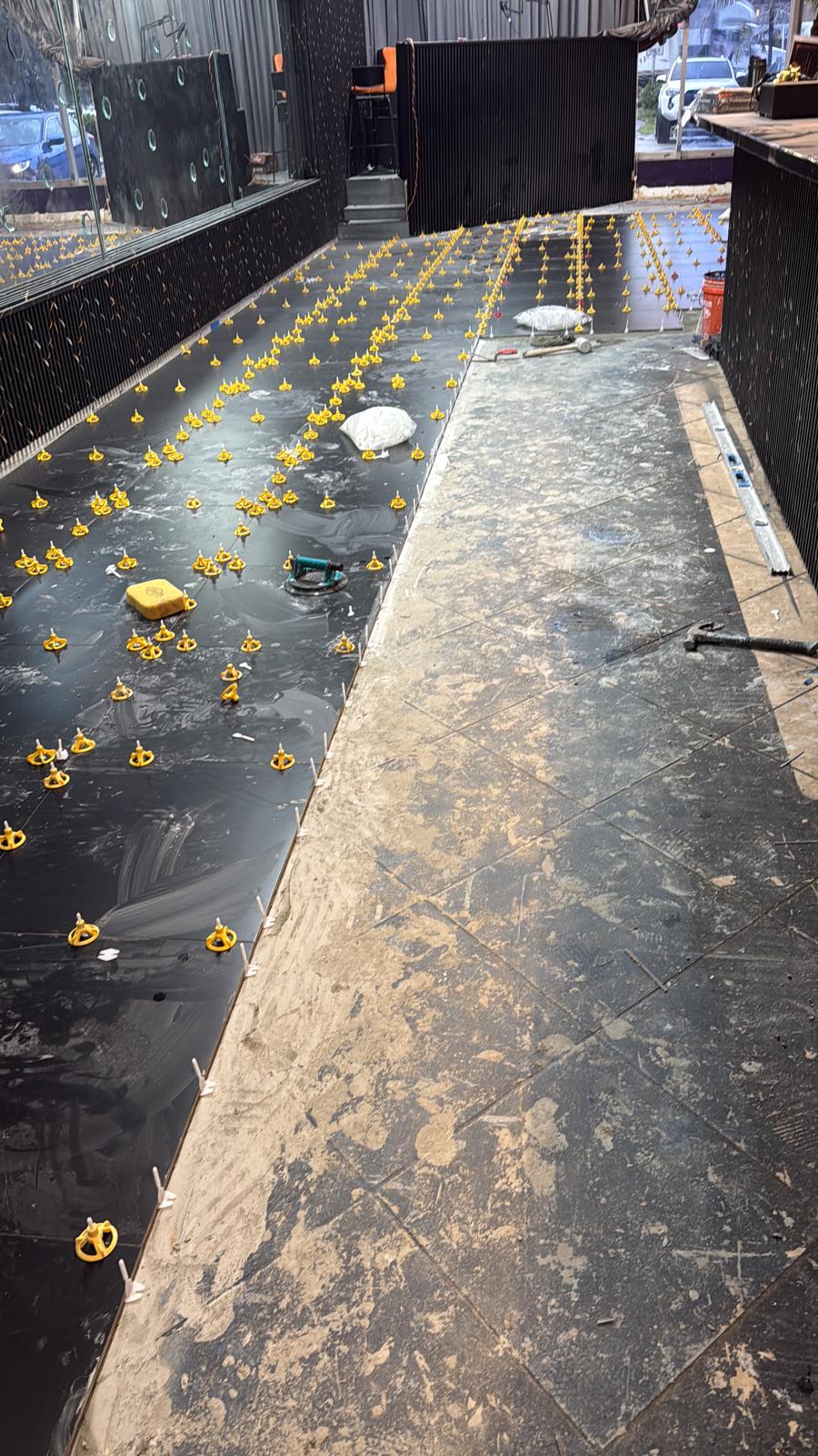 Black tile floor installation at nightclub lounge